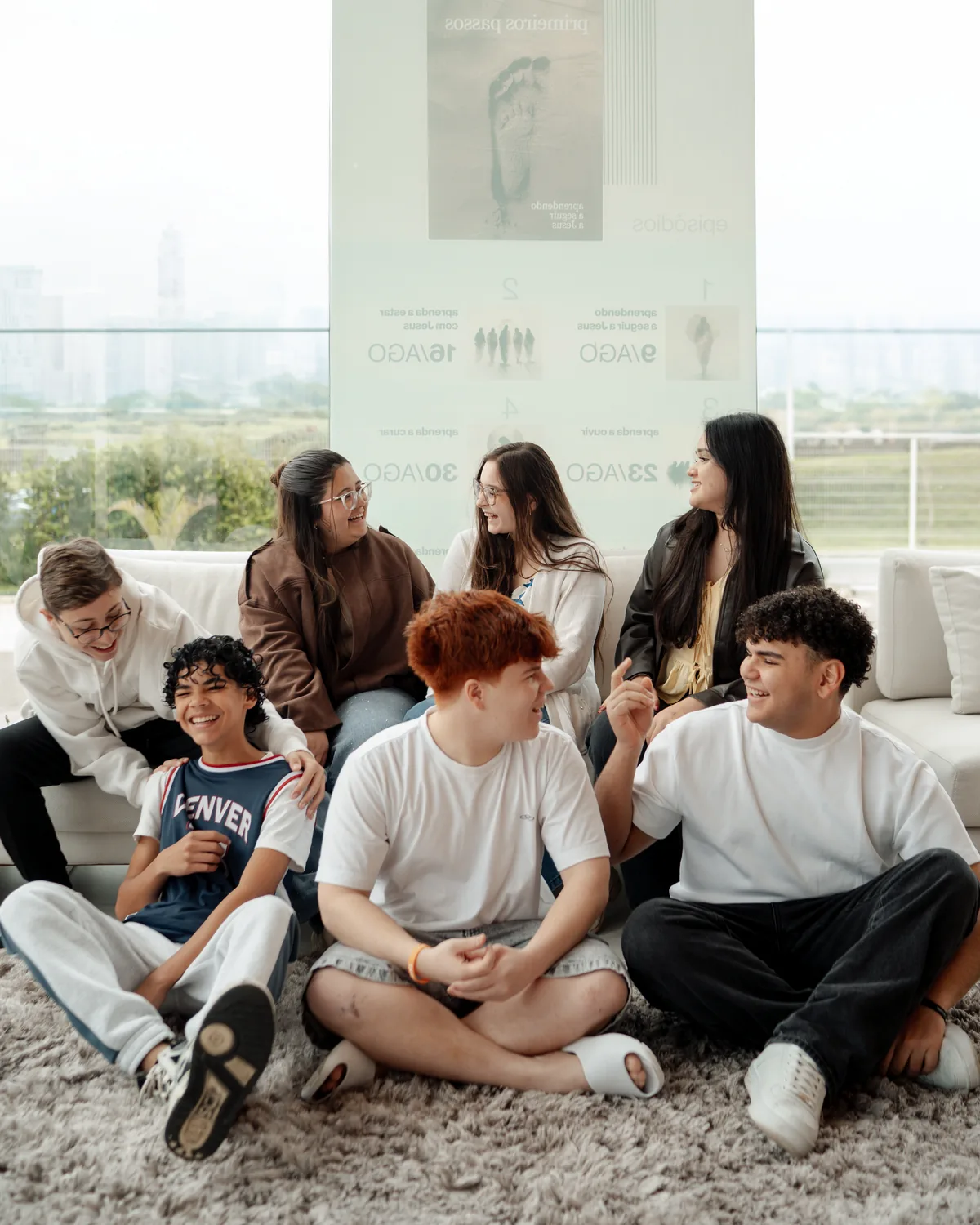 Adolescentes do Recap sentados no chão da sala, rindo juntos