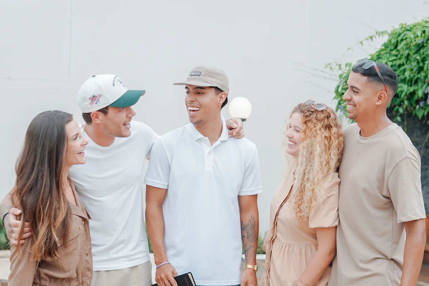 Grupo de amigos conversando na calçada em frente à fachada da Reino