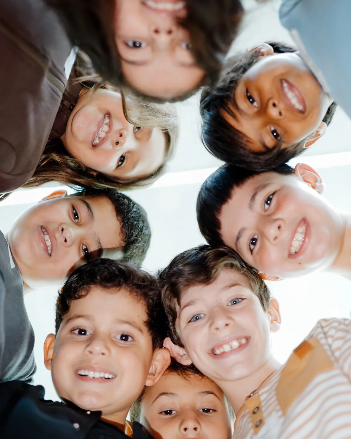Roda de crianças do Reino Kids olhando para a câmera, de cima, sorrindo