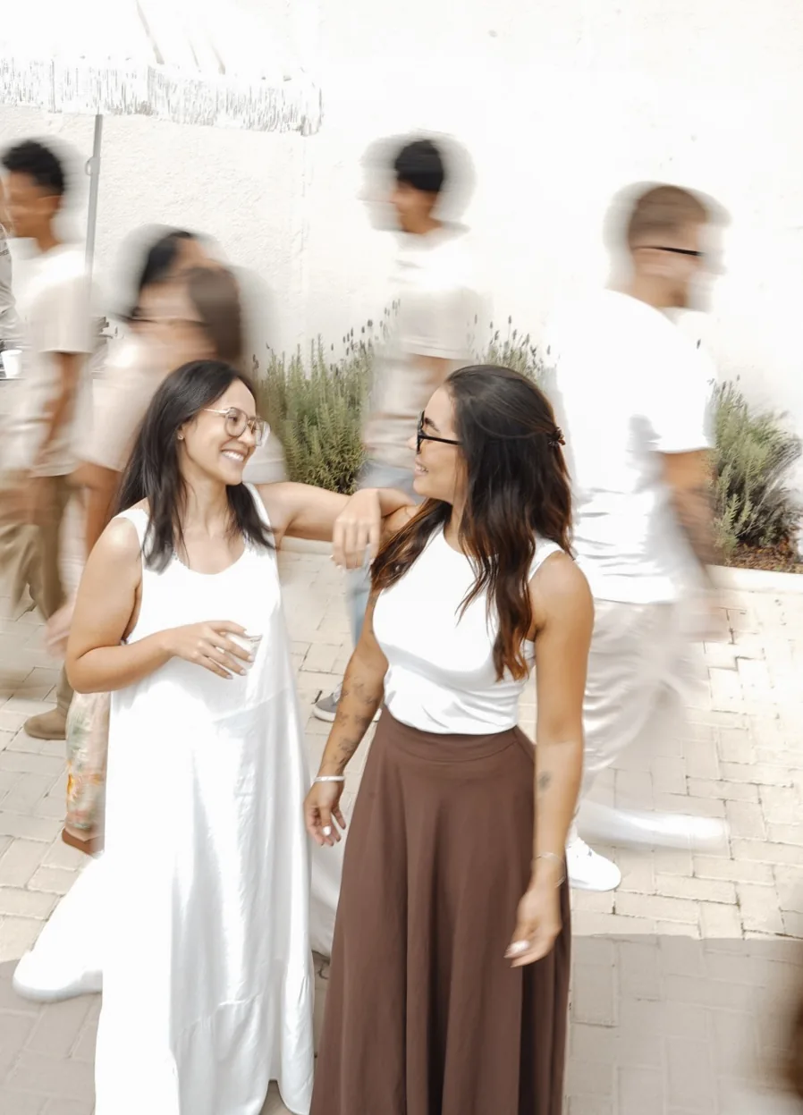 Duas amigas conversam no pátio enquanto a roda passa