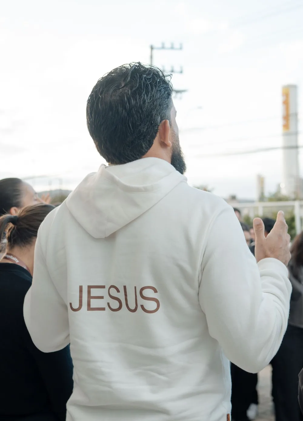 Homem de costas, de moletom branco com a palavra Jesus